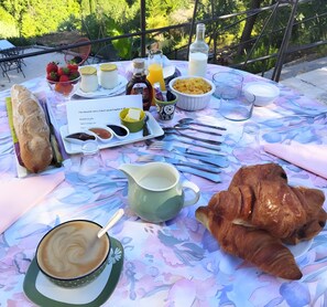Ett frukostbord med croissanter, kaffe och olika tillbehör.
