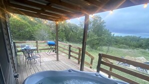A hot tub on a wooden deck with a view of the surrounding landscape. - Secluded Cabin Perfect for Nature and Water Sports Lovers in Texas (Bluff Dale)