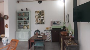Een keuken met een eettafel, stoelen, een koelkast en een fornuis.