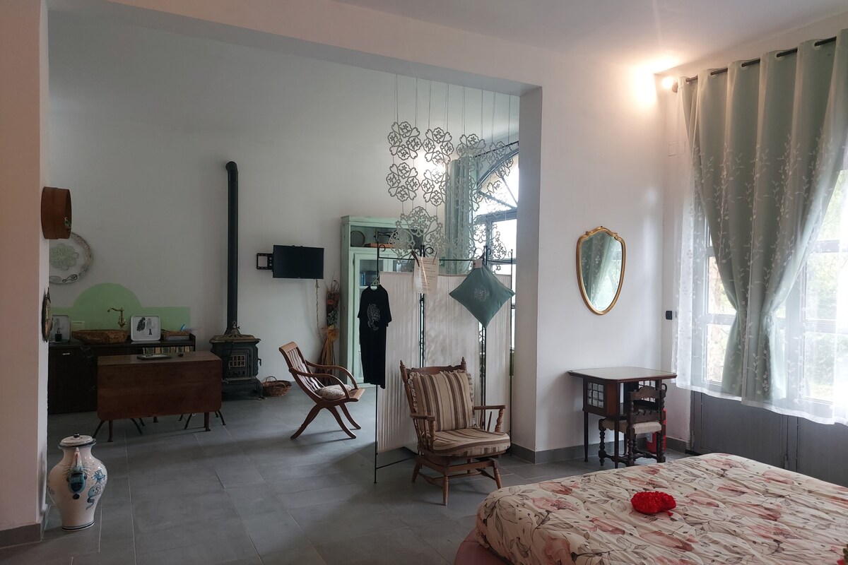 A room with a bed, a dresser, a chair, a mirror, and a window with curtains.