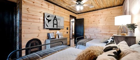 A cozy room with a bed, a ceiling fan, and a wall-mounted artwork.