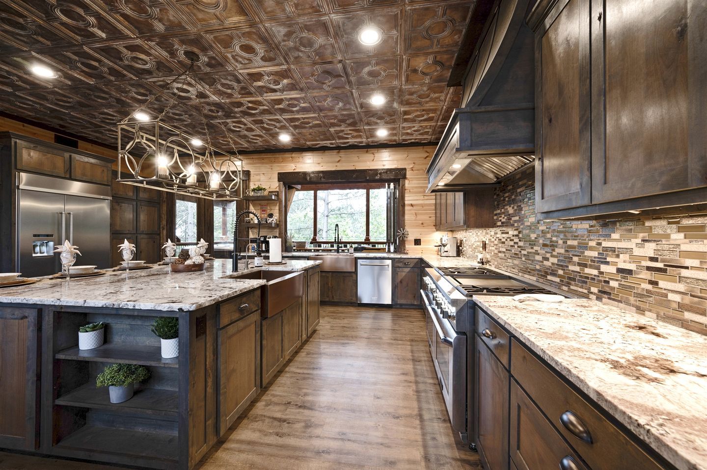 Una cocina moderna con armarios de madera, una isla grande, electrodomésticos de acero inoxidable y vistas a través del ventanal.