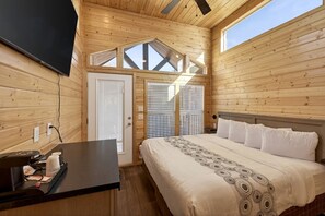 A wooden cabin room with a bed, a desk, and a large window. - Modern Rustic Retreat with Breathtaking Views & Outdoor Bliss in Williams, Arizona (Williams)