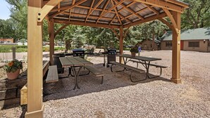 A wooden pavilion with picnic tables and barbecue grills. - Enchanting Pet-Friendly Cabins with Modern Amenities near Garden of the Gods in Colorado Springs, Colorado (Colorado Springs)