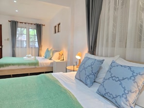A hotel room with two beds, a bedside table with a lamp, and a window with curtains. - Spacious 5-bedroom house with private pool in Jed yod Chiang Mai 5min to Nimman (Chang Wat Chiang Mai)