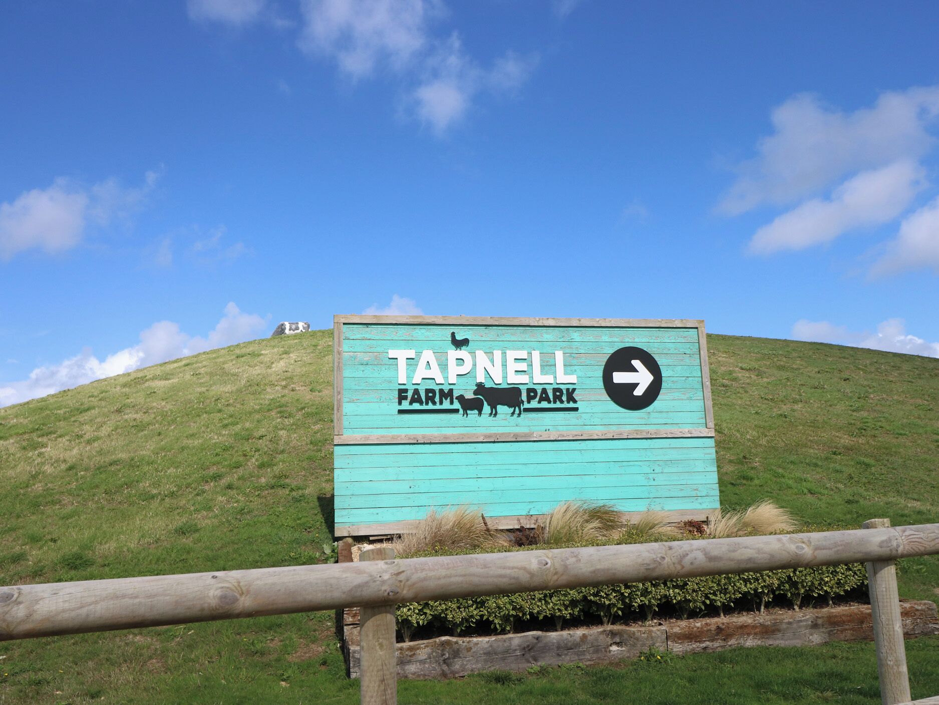 Placa de Tapnell Farm Park com uma seta indicando direção.