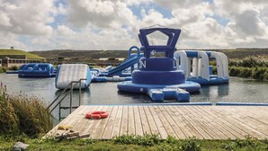 Parque acuático con toboganes inflables y un muelle de madera.