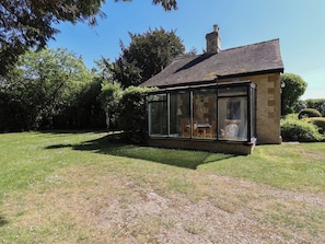 Ein Haus mit Wintergarten, Ziegeldach und Backsteinfassade.