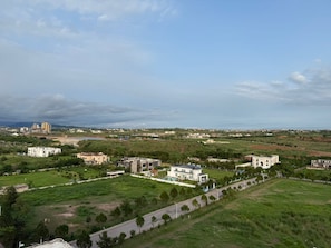 A residential area with modern and traditional buildings, green spaces, and a clear view of the coastline. - 1BR Cozy Apartment, Diamond Mall and Residencia, Gulberg Greens (Islamabad)