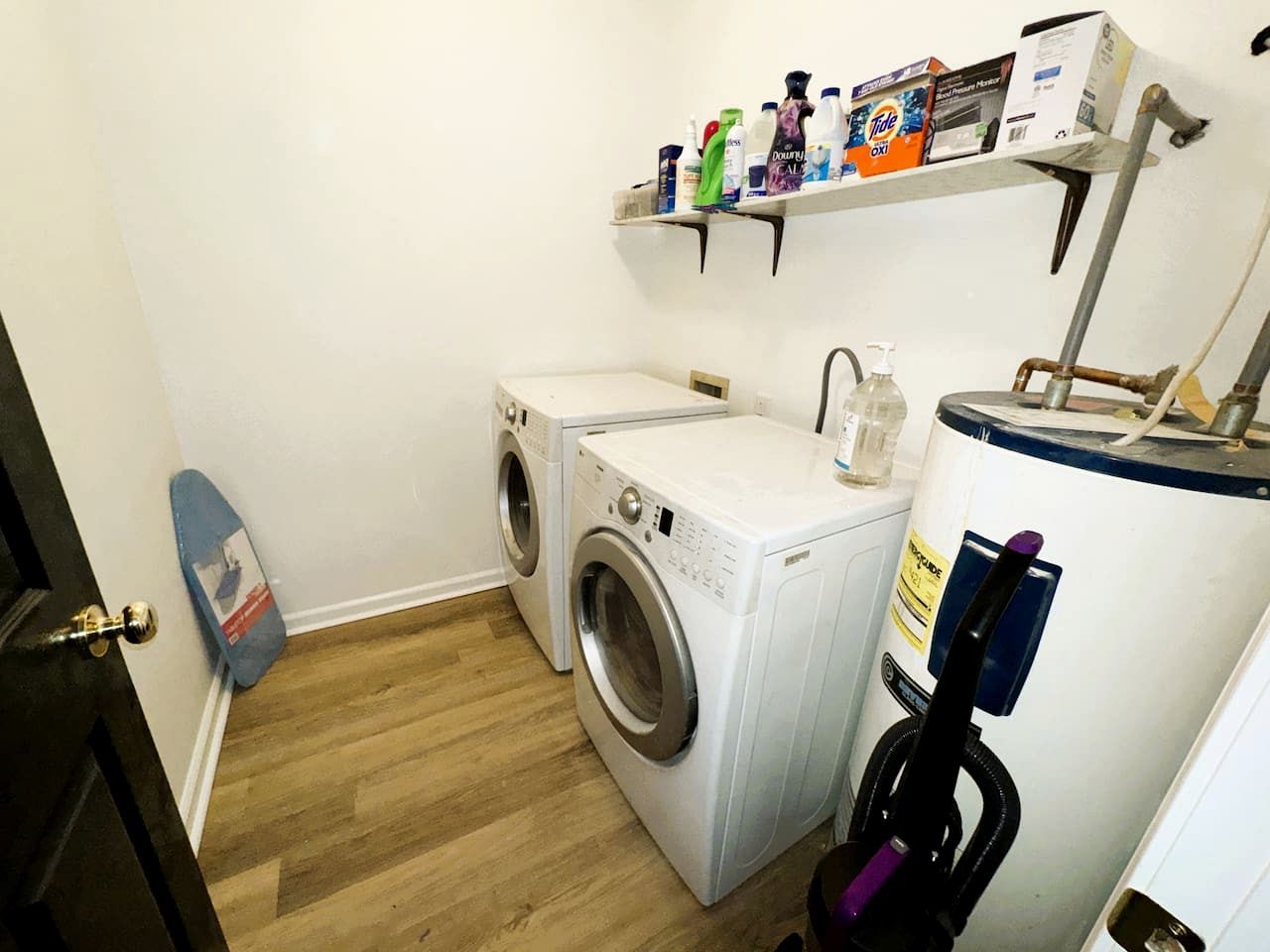 A laundry area with a washing machine, dryer, and a water heater.