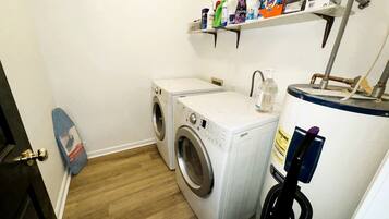 A laundry area with a washing machine, dryer, and a water heater.