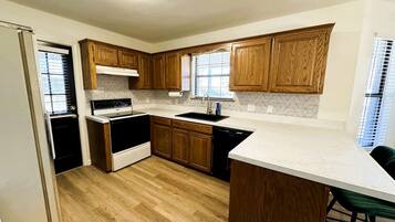 A kitchen with wooden cabinets, a white countertop, and a built-in oven.