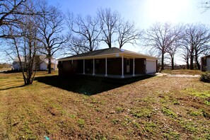 A single-story house with a covered porch and a fenced yard.