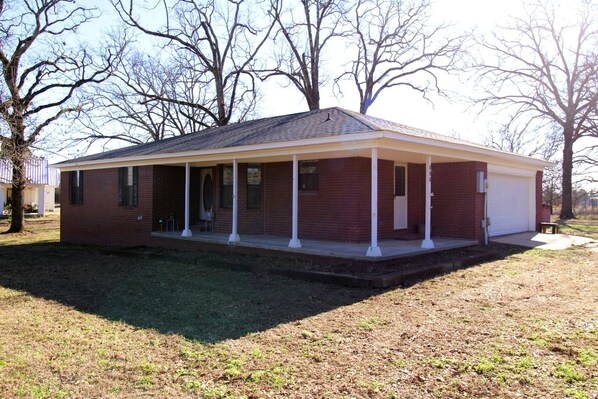 A single-story brick house with a covered porch and a garage.