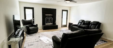 A living room with a fireplace, leather sofas, a coffee table, and a rug.