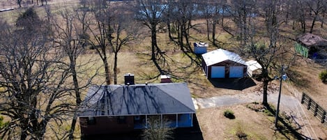 A rural property with a large house, a smaller building, and a fenced area.