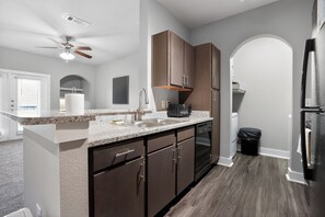 A modern kitchen with granite countertops, stainless steel appliances, and wooden cabinets. - Bright & spacious 1bedroom retreat (New Braunfels)