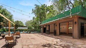 An outdoor patio with stone flooring, wooden furniture, and string lights. - Rustic-Chic Cabins with Scenic Woodland Views Near Garden of the Gods in Colorado Springs, Colorado (Colorado Springs)
