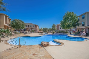 A swimming pool area with lounge chairs and a stone pathway. - Modern 1br living in New Braunfels (New Braunfels)