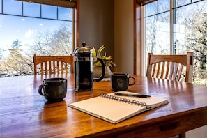 A wooden table with a coffee maker, two mugs, and a notebook. - Relaxing Coastal Getaway with Bay Views in Blaine, Washington (Blaine)