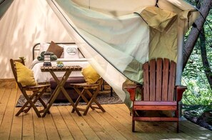 A tent with a bed, a table, two chairs, and a wooden bench. - Family Deluxe #2 (Broadalbin)