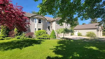 A residential house with a front yard, a garage, and a staircase leading to the entrance.