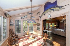 A cabin interior with a dining area, wooden walls, and fish-themed decorations.