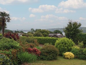 A garden with various plants and a house with solar panels. - 7 Chycoose Parc (Truro)