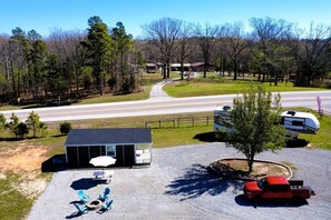 A campground with RVs, a small cabin, and a gravel parking area. - Charming Tiny Home Retreat Near Forest Trails & River Access in Calico Rock, Arkansas (Calico Rock)