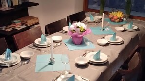 Una tavola imbandita con piatti, posate, tovaglioli e un centrotavola.
