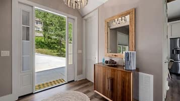 Een modern interieur met een houten kast, een grote spiegel en uitzicht op de omgeving.