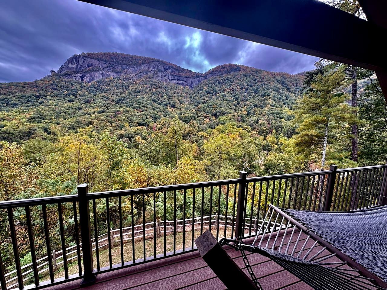 A balcony with a view of a forested mountain.