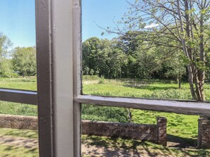 A view through a window with a brick wall and a grassy field. - Walk House (Gloucester)