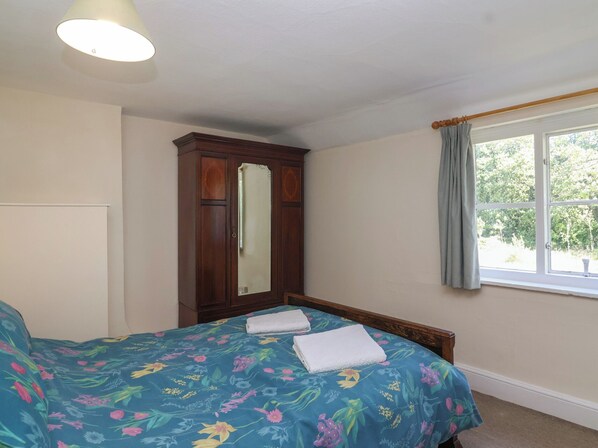 A bedroom with a bed, a wardrobe, a window with curtains, and a ceiling light. - Walk House (Gloucester)