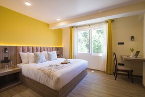 A bedroom with a large bed, bedside tables, a desk with a laptop, and a window with curtains. - Alaya Stays Baljees Melville Divine 1BHK (Shimla)