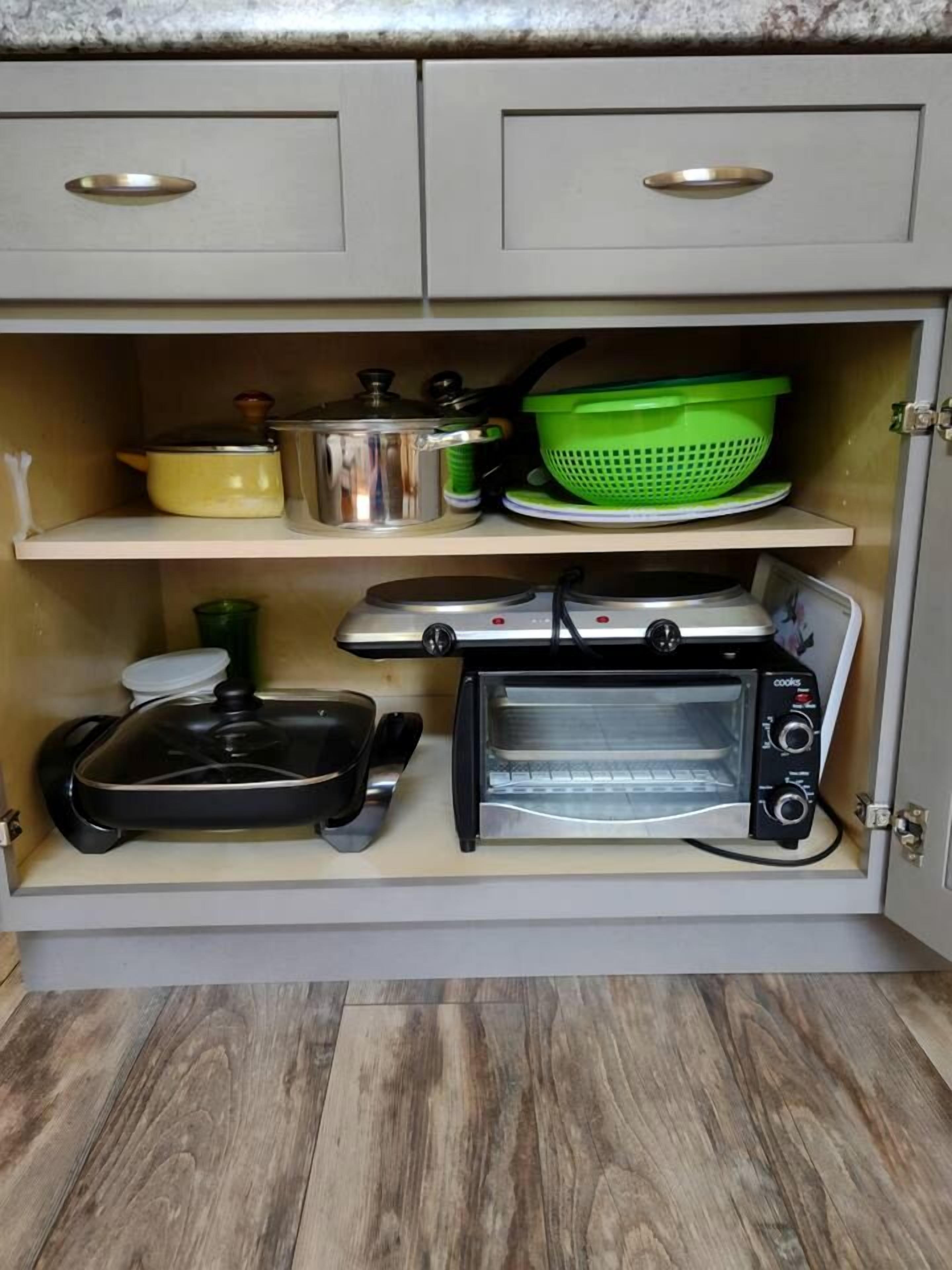 A kitchen with a built-in oven, a toaster, and a microwave.