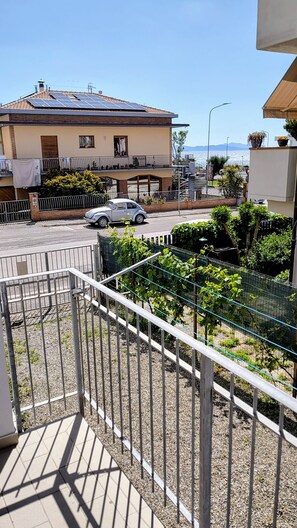 Ein Wohngebiet mit einem Haus, das Solaranlagen, einen Balkon mit Metallgeländer und Meerblick bietet.