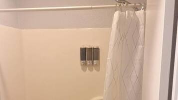 A bathroom with a bathtub, toilet, and a shower curtain.