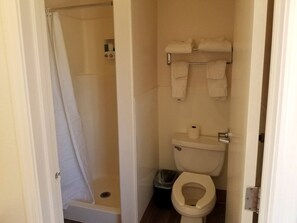 Ein kleines Badezimmer mit Dusche, Toilette und Handtuchhalter.