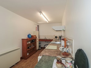 A compact kitchen with a refrigerator, microwave, sink, and a small cabinet. - Walk Close (Gloucester)