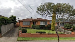A residential house with a front yard, a driveway, and a wooden fence. - Convenient Glenroy Accommodation Ideal for Airport Travellers (Melbourne)