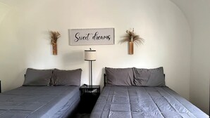 A double bed room with two beds, a bedside table, a lamp, and a wall sign. - Unforgettable Sasquatch Ranch Retreat with Goats & Beach Area near Littleton, NC (Littleton)