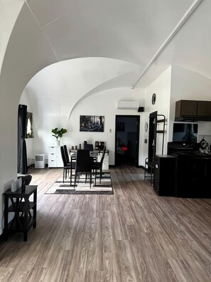 Una cocina moderna con comedor, techo blanco y suelo de madera.