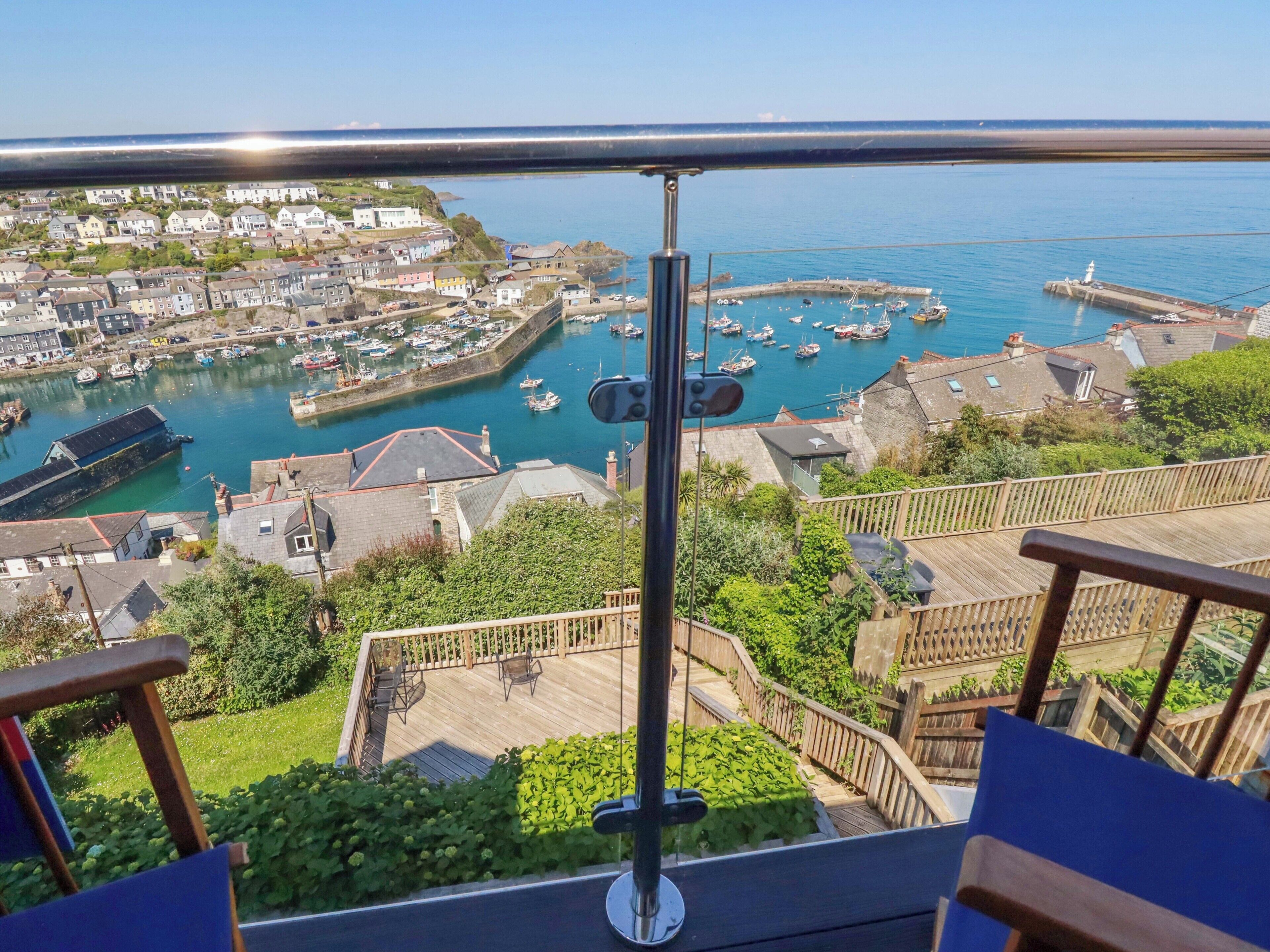 Un balcon donnant sur un port, des bateaux et une ville.
