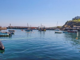 Un puerto con barcos, un faro y un edificio en una colina.