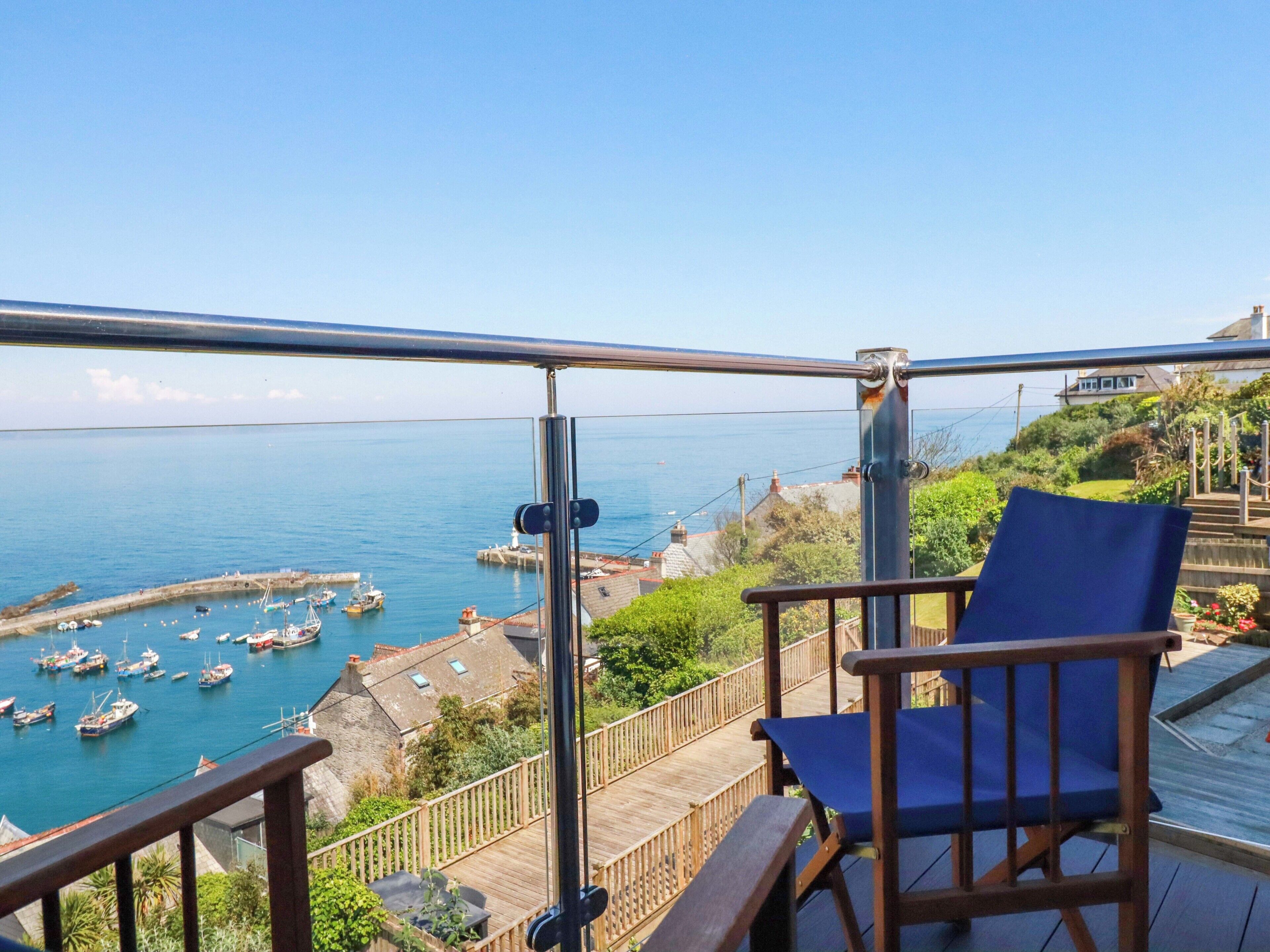 Ein Balkon mit Blick auf einen Hafen, ein Stuhl und ein Holzdeck.