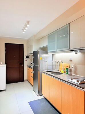 Una cocina moderna con electrodomésticos de acero inoxidable, armarios de madera y un microondas integrado.
