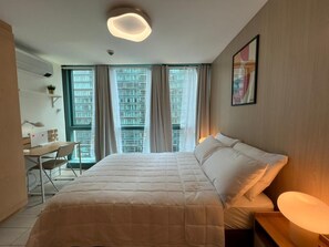 A hotel room with a bed, desk, chair, and a large window with curtains. - New! Serene & Cozy,  1 bedroom, Wi-Fi 350Mbps  Uptown BGC, Step from Mall BH6 (Taguig)