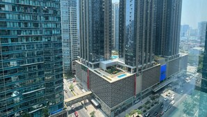 A high-rise building with multiple floors, large windows, and a rooftop area. - New! Serene & Cozy,  1 bedroom, Wi-Fi 350Mbps  Uptown BGC, Step from Mall BH6 (Taguig)