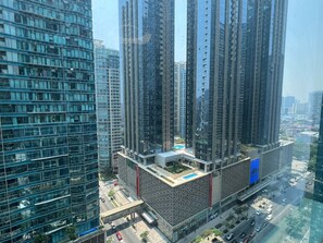 A high-rise building with multiple floors, large windows, and a rooftop area. - New! Serene & Cozy,  1 bedroom, Wi-Fi 350Mbps  Uptown BGC, Step from Mall BH6 (Taguig)